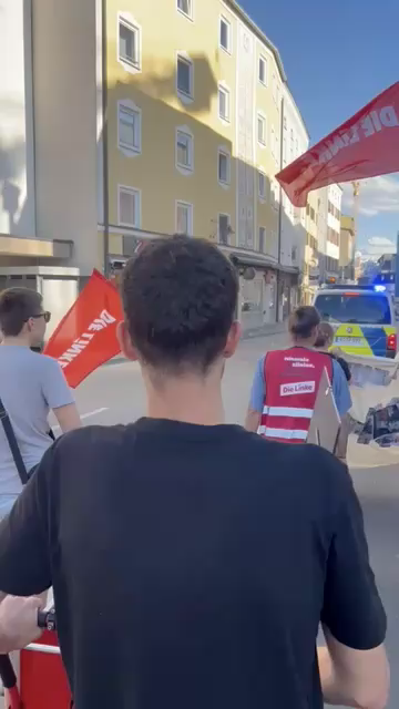 Video aus einem Demozug heraus, der bei sonnigem Wetter durch eine Altstadt zieht. Vorneweg fährt ein Polizeiwagen. Die Leute schwenken Linke-Fahnen, eine davon ist am Ende groß im Bild und beschließt die Sequenz. Dazu läuft Musik von Knorkator: Die Welt braucht keine Milliardäre, stellt euch vor, wie schön es ohne euch wäre.